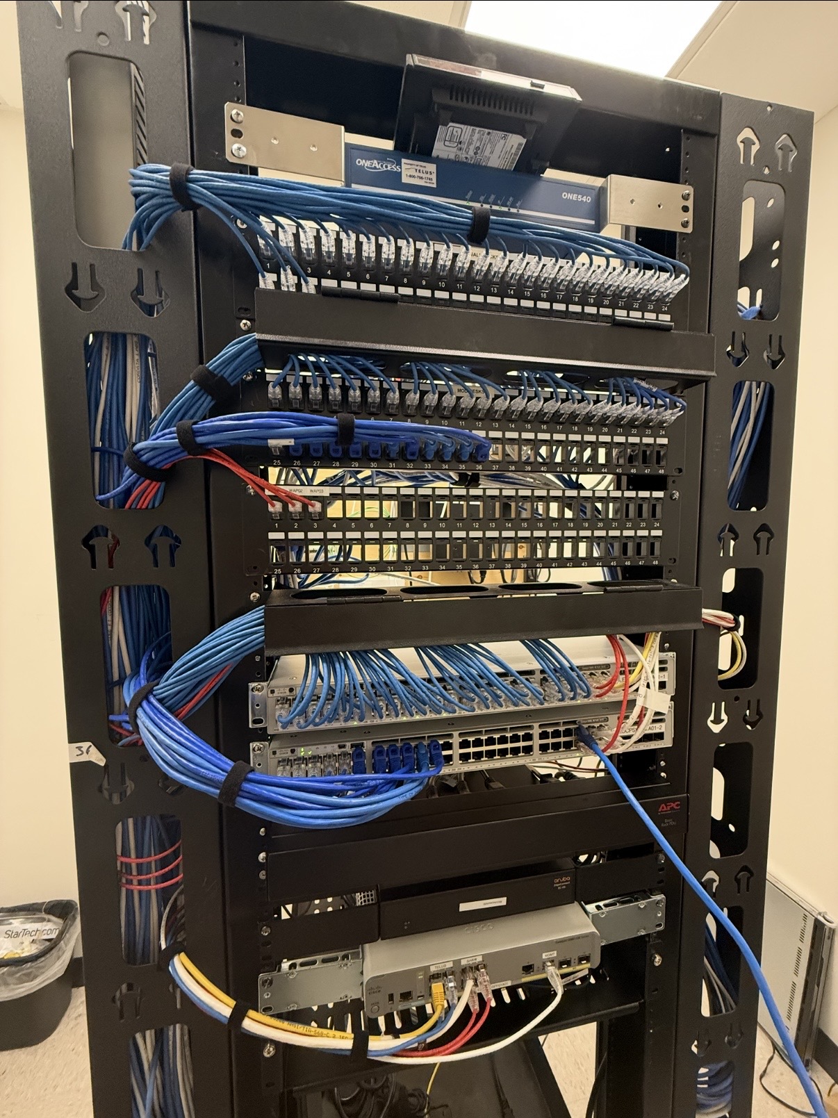 Completed network rack with blue cables neatly routed and secured