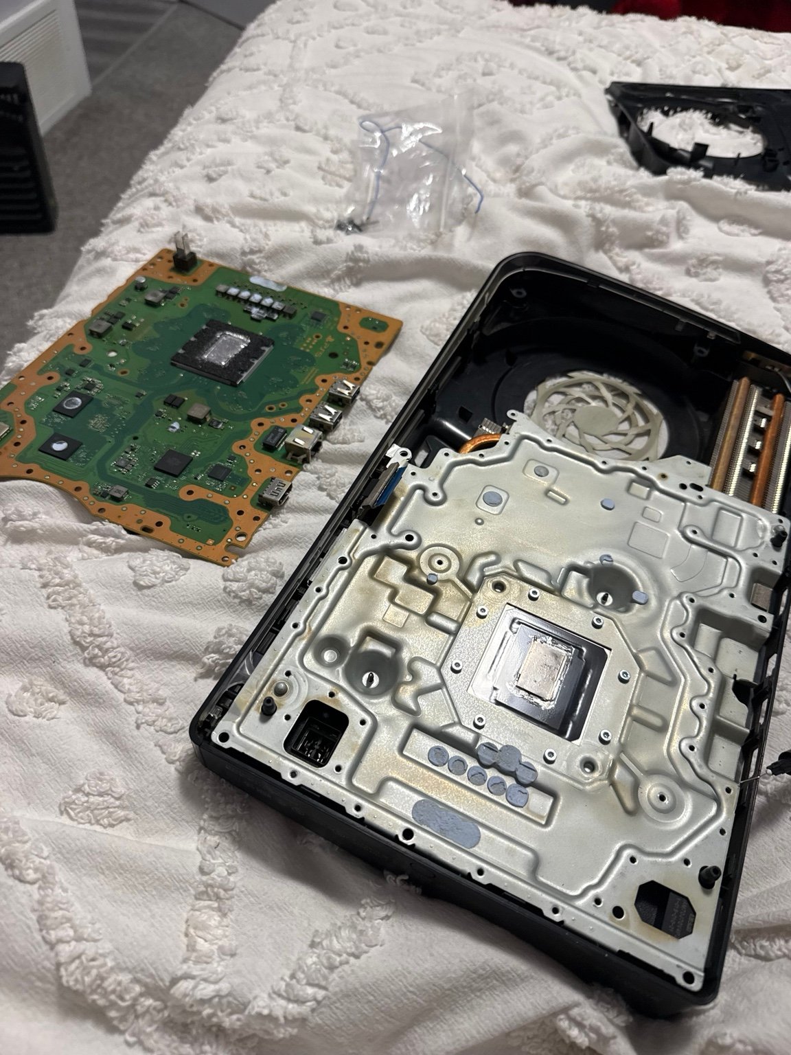 Disassembled PS5 showing motherboard, fan and thermal contact surfaces