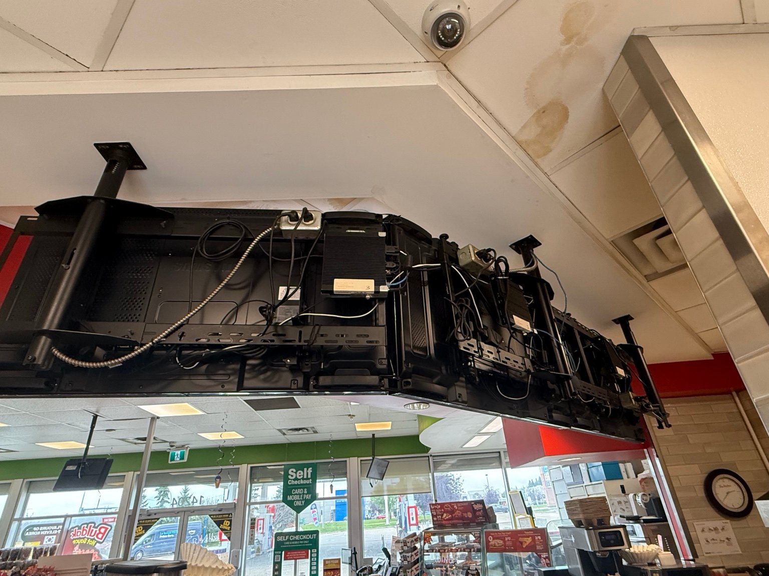 Rear of commercial menu displays showing mounting hardware, media players and cabling