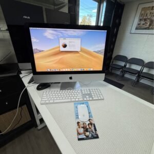 Apple iMac 21.5-inch on a desk with Apple keyboard and mouse, showing macOS About This Mac
